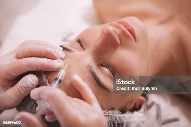 Beautiful Young Woman At Cosmetology Clinic Stock Photo - Download Image Now - Botulinum Toxin Injection, Injecting, Forehead