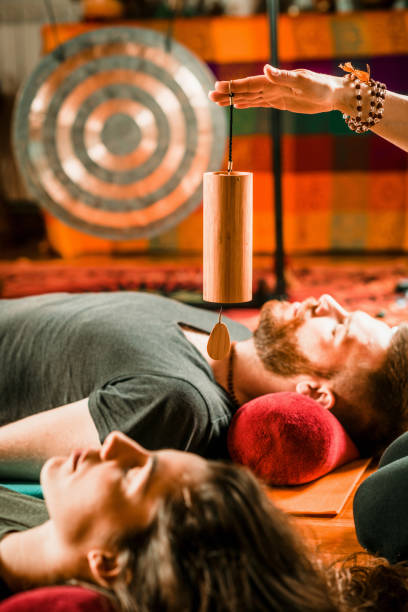 istock Therapist Holding Equipment Over Couple While Performing Music Therapy At Spa 1188599208