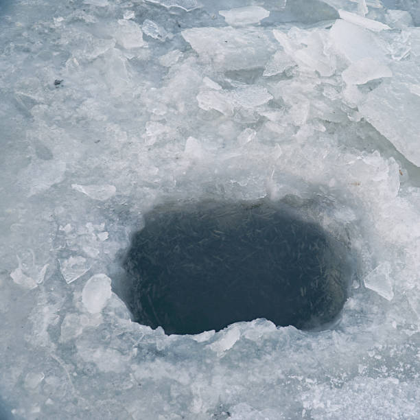 istock Ice hole in ice for winter fishing 1188602119