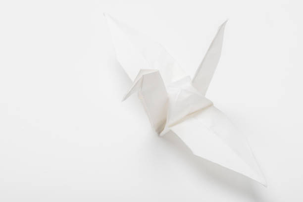 Origami art. Handmade paper crane on orange background, closeup