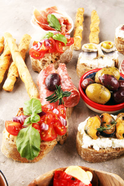 istock Appetizers table with italian antipasti snacks and wine in glasses. Brushetta or authentic traditional spanish tapas set, cheese variety 1188604115