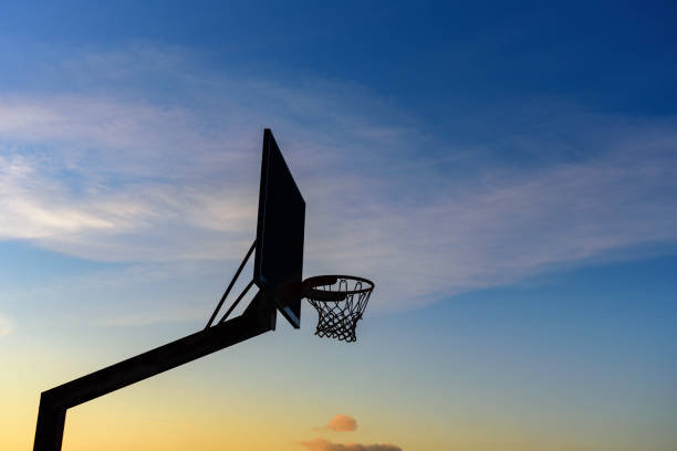 Street basketball hoop on sunset sky. Goal and win concept