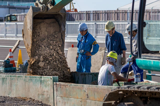 Group of japanese constructors working on the street using an excavator in Kanazawa, Japan stock photo