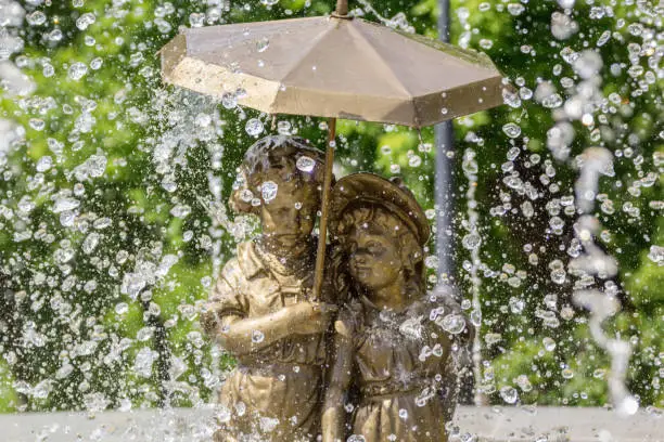 Fountain boy and girl under an umbrella in Samara, Russia