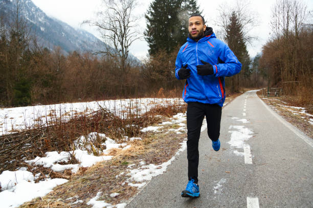 uomo che corre in inverno - running jogging african descent nature foto e immagini stock