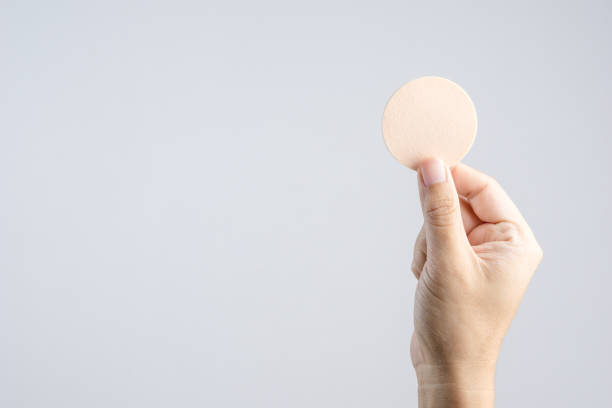 istock Hand holding round brown face sponge for cosmetic 1188611187