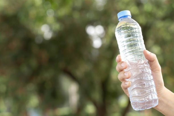 istock young man Hand holding fresh drinking water bottle from a plastic in the park. 1188611519
