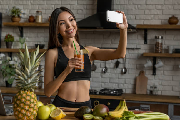 istock Sport female blogger making selfie with smoothie drink using smartphone at home kitchen 1188611520