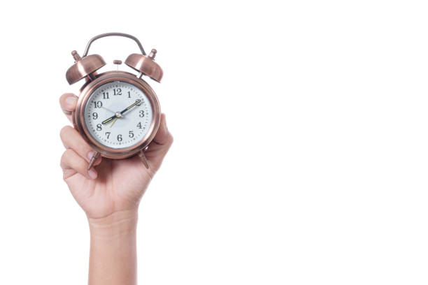 istock Hand holding vintage alarm clock setting at 7am and showing time over eight o'clock for being late 1188612852