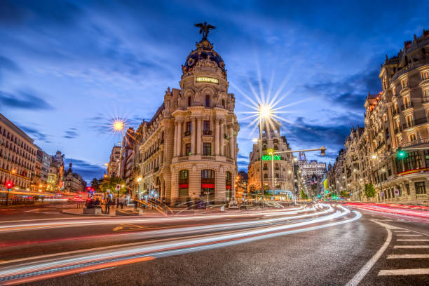 гран через в мадриде на закате с легкими тропами. испания - metropolis building стоковые фото и изображения