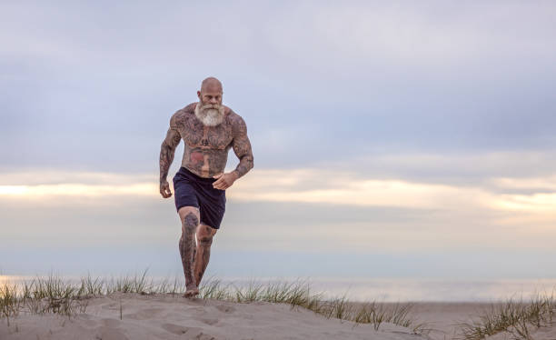 istock Tattooed Senior Man During beach Workout 1188613600