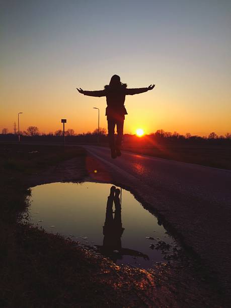 a person flying against sunset