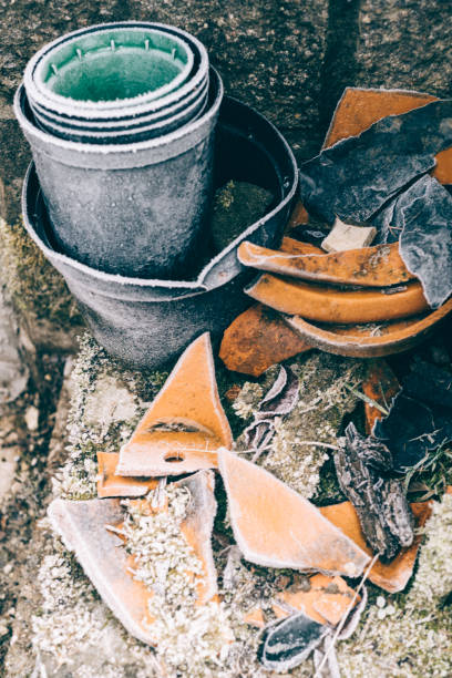 Frozen corner of a garden with clay and plastic flower pots.