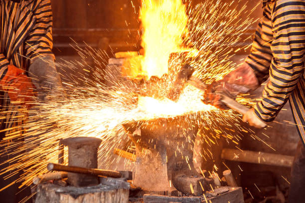 istock Blacksmith forging the molten metal with a hammer to make keris 1188618299