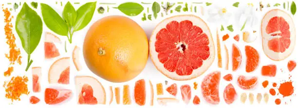 Large collection of grapefruit pieces, slices and leaves isolated on white background. Top view. Seamless abstract pattern.