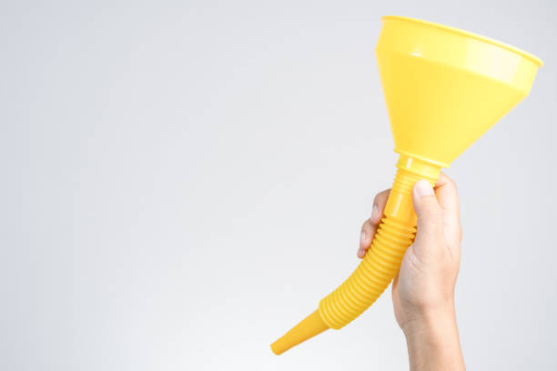 istock Hand holding yellow plastic funnel cone for water or fluid transfer 1188621136