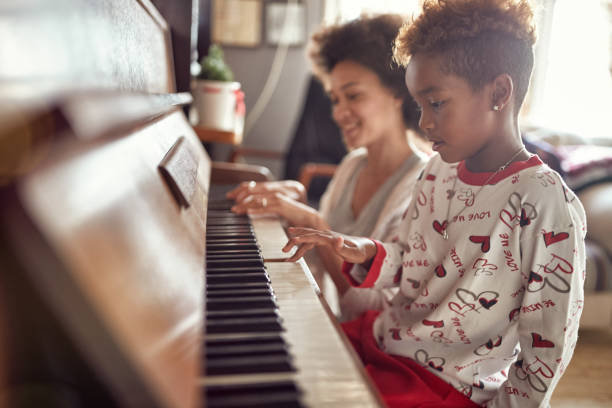 girl is playing on piano x-mas music. concept christmas, new year, holiday, family happiness, childhood. - family american culture african culture black imagens e fotografias de stock