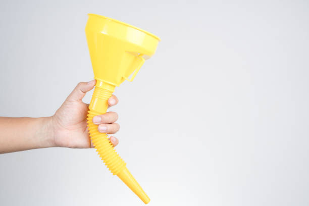 istock Hand holding yellow plastic funnel cone for water or fluid transfer 1188624962