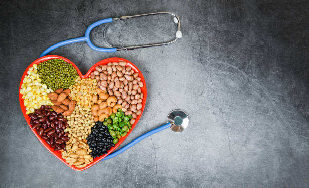 Different whole grains beans and legumes seeds lentils and nuts colorful on red heart background / Collage various beans mix peas agriculture of natural healthy food for cooking ingredients diferentes granos enteros frijoles y legumbres semillas lentejas y frutos secos colorido sobre el fondo del corazón rojo - collage varios frijoles mezclan guisantes agricultura de alimentos saludables naturales para ingredientes de cocina