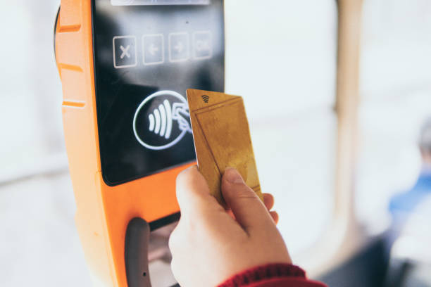 Payment of public transport ticket fare at automatic contactless machine with a card stock photo