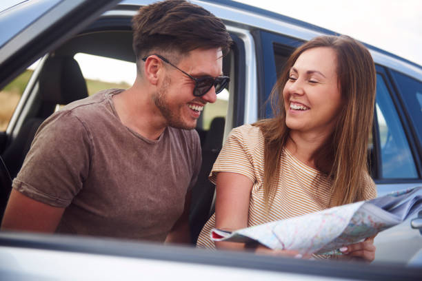 istock Young couple reading a map during road trip 1188628780