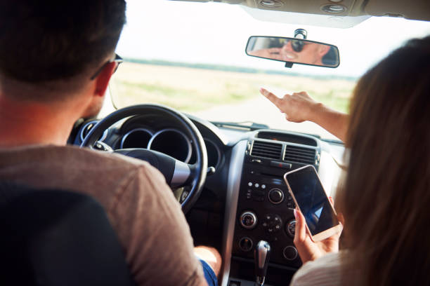 istock Young couple using a mobile phone during road trip 1188629142