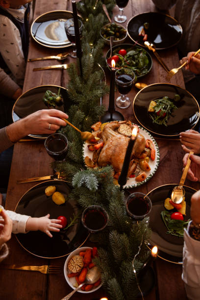 istock Winter holidays dinner table with turkey, vegetables and wine. Cozy atmosphere. 1188631936
