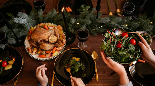 istock Winter holidays dinner table with turkey, vegetables and wine. Cozy atmosphere. 1188631938
