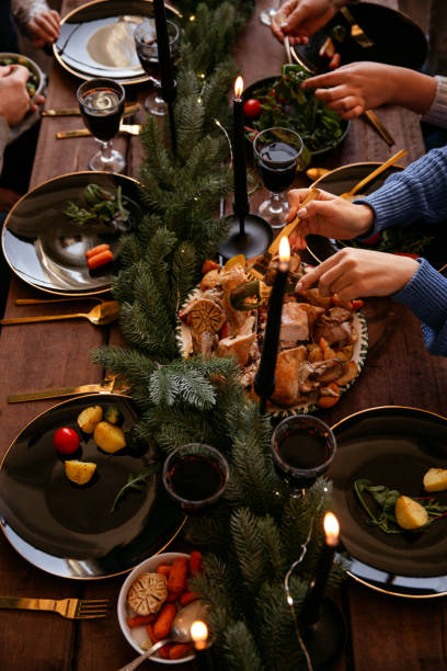 istock Winter holidays dinner table with turkey, vegetables and wine. Cozy atmosphere. 1188631950