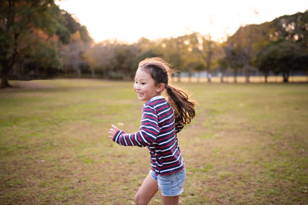 istock Smiling girl playing in the park at sunset 1188632089