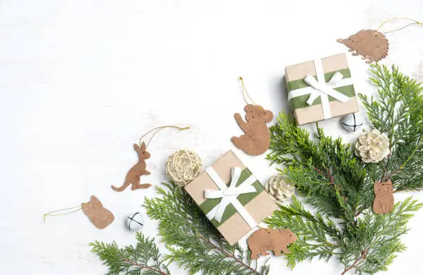 Australia inspired rustic Christmas flat-lay featuring native Australian mammals amongst Christmas foliage and gifts on a white background.