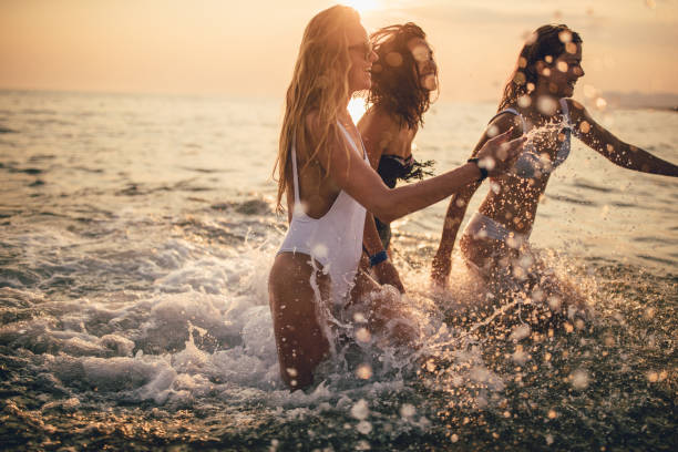Happy friends running,splashing having fun in the sea