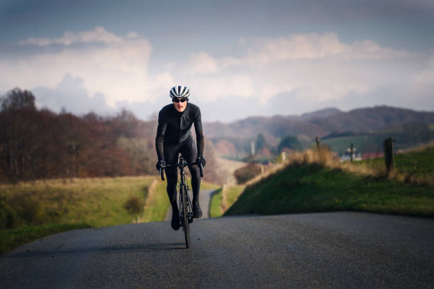 cyclist out for a winter training ride in denmark. - white denmark nordic countries winter imagens e fotografias de stock