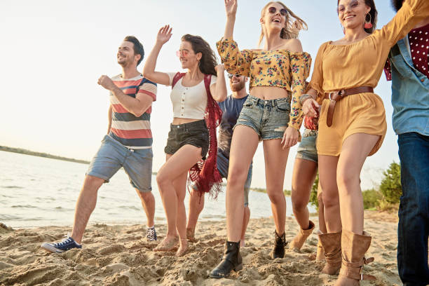 istock Group of young people running on the beach 1188636325