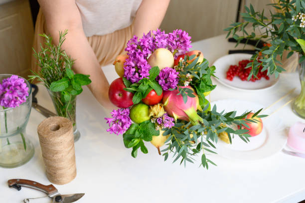istock the process of forming a fruit and flower bouquet. tutorial, do it yourself. photo 23, women's hands glues the details of the bouquet to each other with sellotape 1188637550