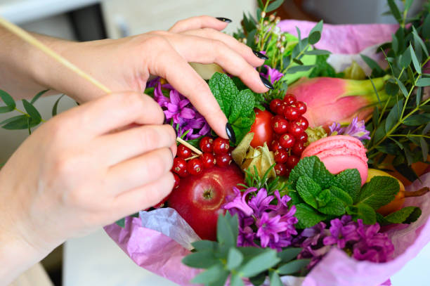 istock the process of forming a fruit and flower bouquet. tutorial, do it yourself. photo 37, women's hands a long wooden skewer inserts red currants into the bouquet 1188637577