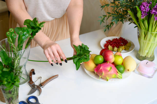 istock the process of forming a fruit and flower bouquet. tutorial, do it yourself. photo 9, women's hands inserts mint into a vial orchid long stem 1188637599