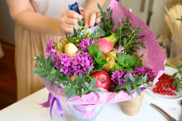 istock the process of forming a fruit and flower bouquet. tutorial, do it yourself. photo 33, women's hands staples packaging and tissue paper 1188637620