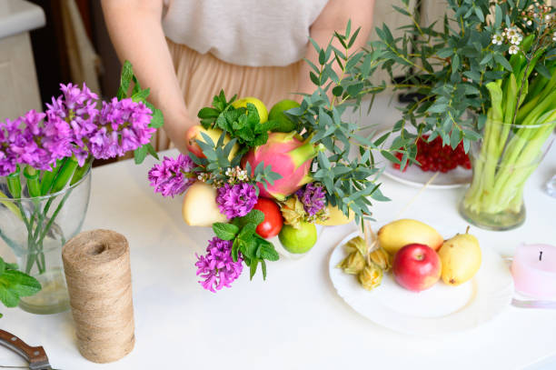 istock the process of forming a fruit and flower bouquet. tutorial, do it yourself. photo 22, women's hands glues the details of the bouquet to each other with sellotape 1188637936