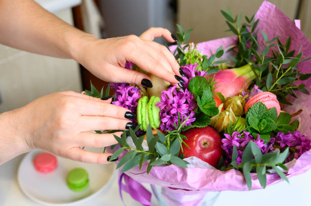 istock the process of forming a fruit and flower bouquet. tutorial, do it yourself. photo 35, women's hands correct the details of the bouquet 1188637963