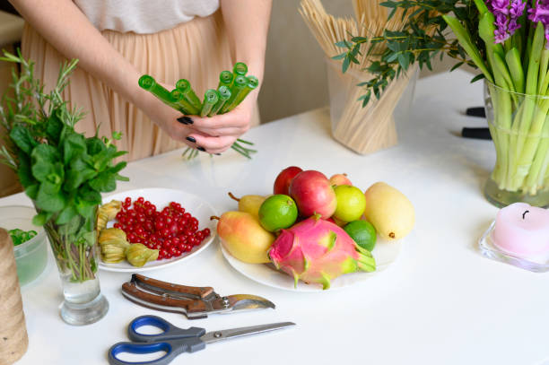istock the process of forming a fruit and flower bouquet. tutorial, do it yourself. photo 7, women's hands holding vial orchid long stem 1188638106