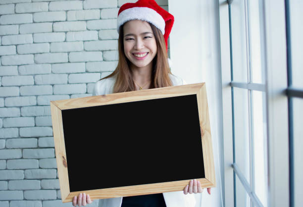 mulher que desgasta o chapéu para o natal ou a celebração do ano novo - placard holding celebration women - fotografias e filmes do acervo