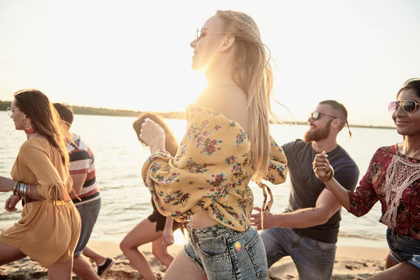 istock Group of young people running on the beach 1188640843