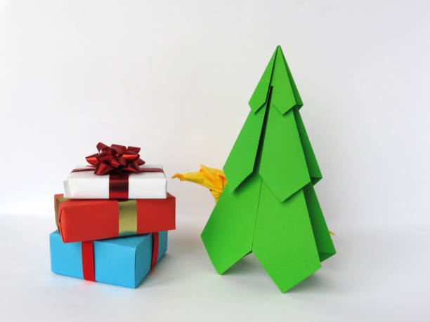 istock Christmas tree and origami rat, gift boxes stacked in a pile with bows on a white background. 1188641098
