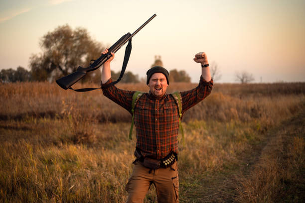 młody irlandzki patrząc czerwony brodaty myśliwy ze strzelbą w ręku świętując udane polowanie na wiejskim torze upiększać jesienny dzień - hunting rifle sniper duck hunting zdjęcia i obrazy z banku zdjęć