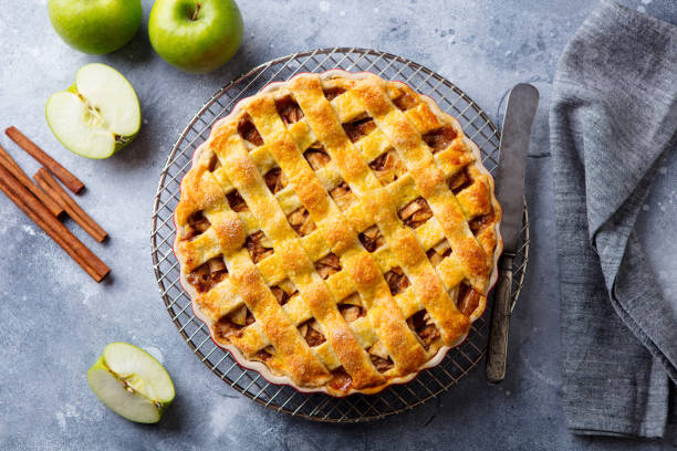 istock Apple pie with caramel on a cooling rack. Grey background. Top view. 1188643351