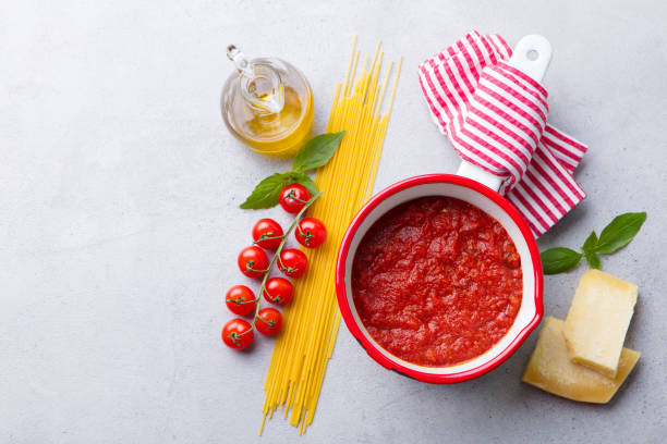 sauce tomate traditionnelle dans une casserole avec pâtes spaghetti. fond gris. copiez l'espace. vue du haut. - macaroni cheese food staple casserole photos et images de collection