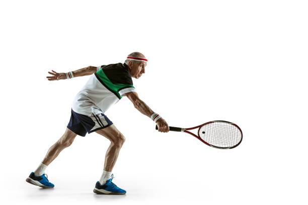 uomo anziano che gioca a tennis in abbigliamento sportivo isolato su sfondo bianco - tennis men indoors serving foto e immagini stock