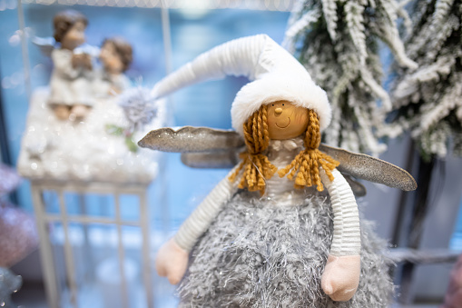 Christmas doll angel girl in white cap and wings, festive interior decoration in the house