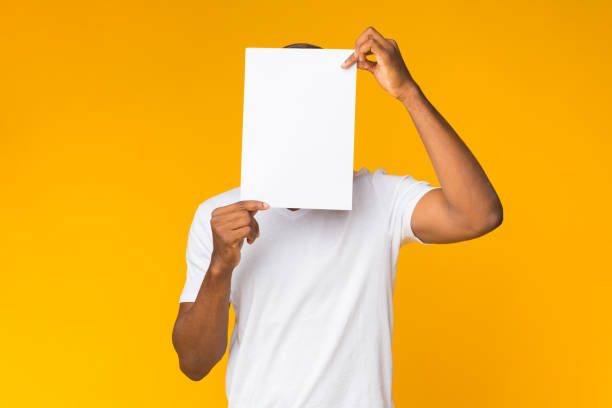 istock Man Standing Covering Face With White Paper, Studio Shot 1188648072